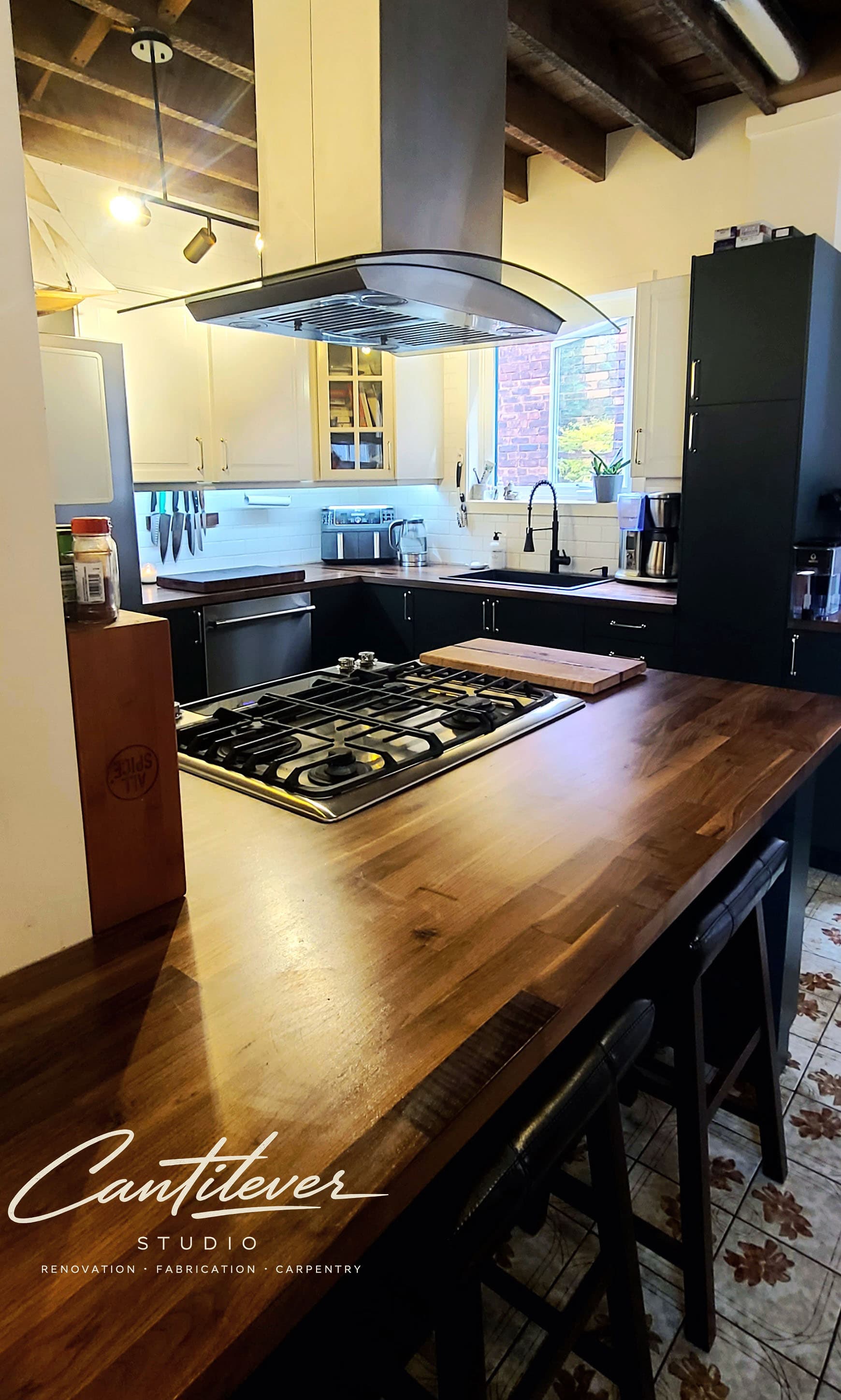 Cantilever Studio kitchen renovation with island, cabinetry, and range hood.