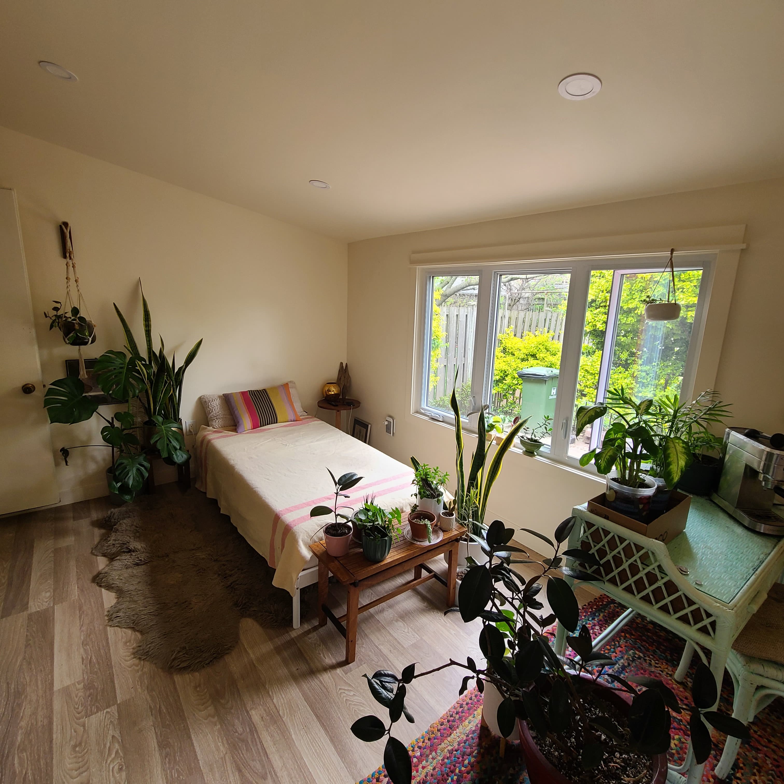 Finished rear addition room with wide windows, pale flooring, and a compact lounge layout.